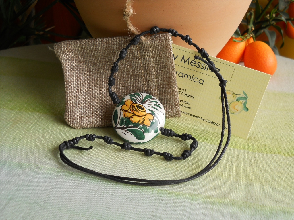 Questa collana ha un ciondolo di ceramica a forma di bottone dove ho dipinto a mano un fiore; indossandola porterai al collo il profumo della Sicilia!